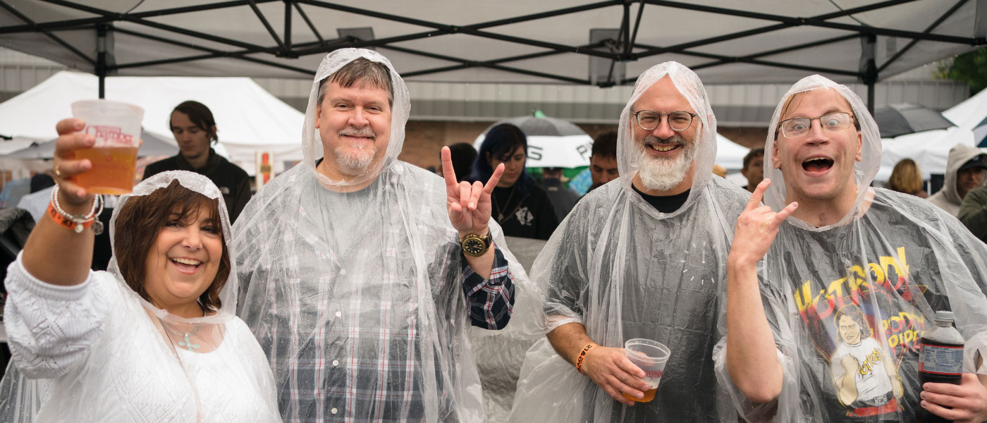 group of four people cheering with rain coats on