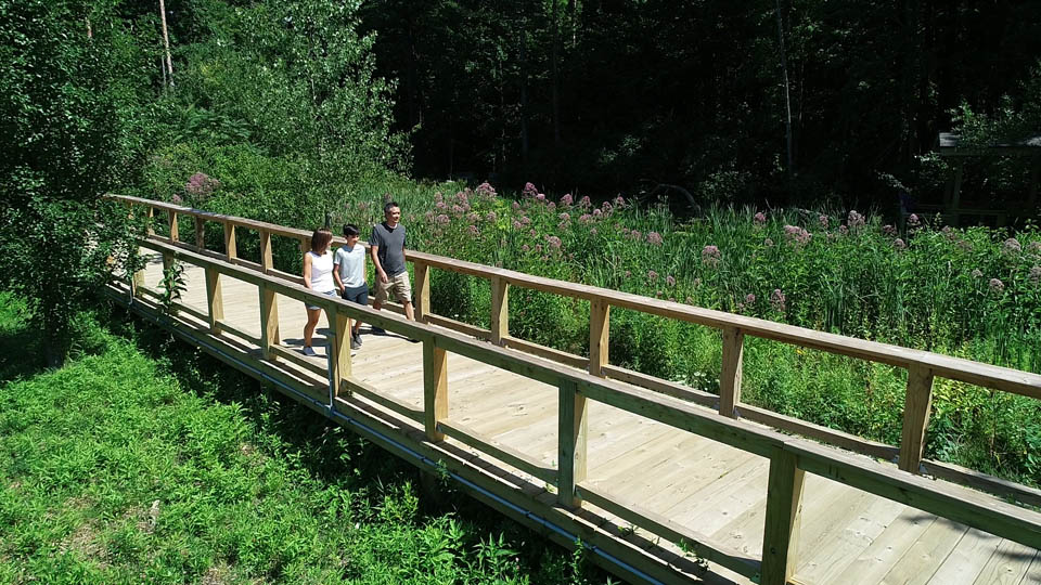 family walking on a trail bridge