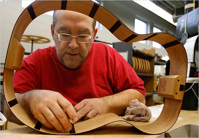 A man building a guitar by hand at Martin Guitars