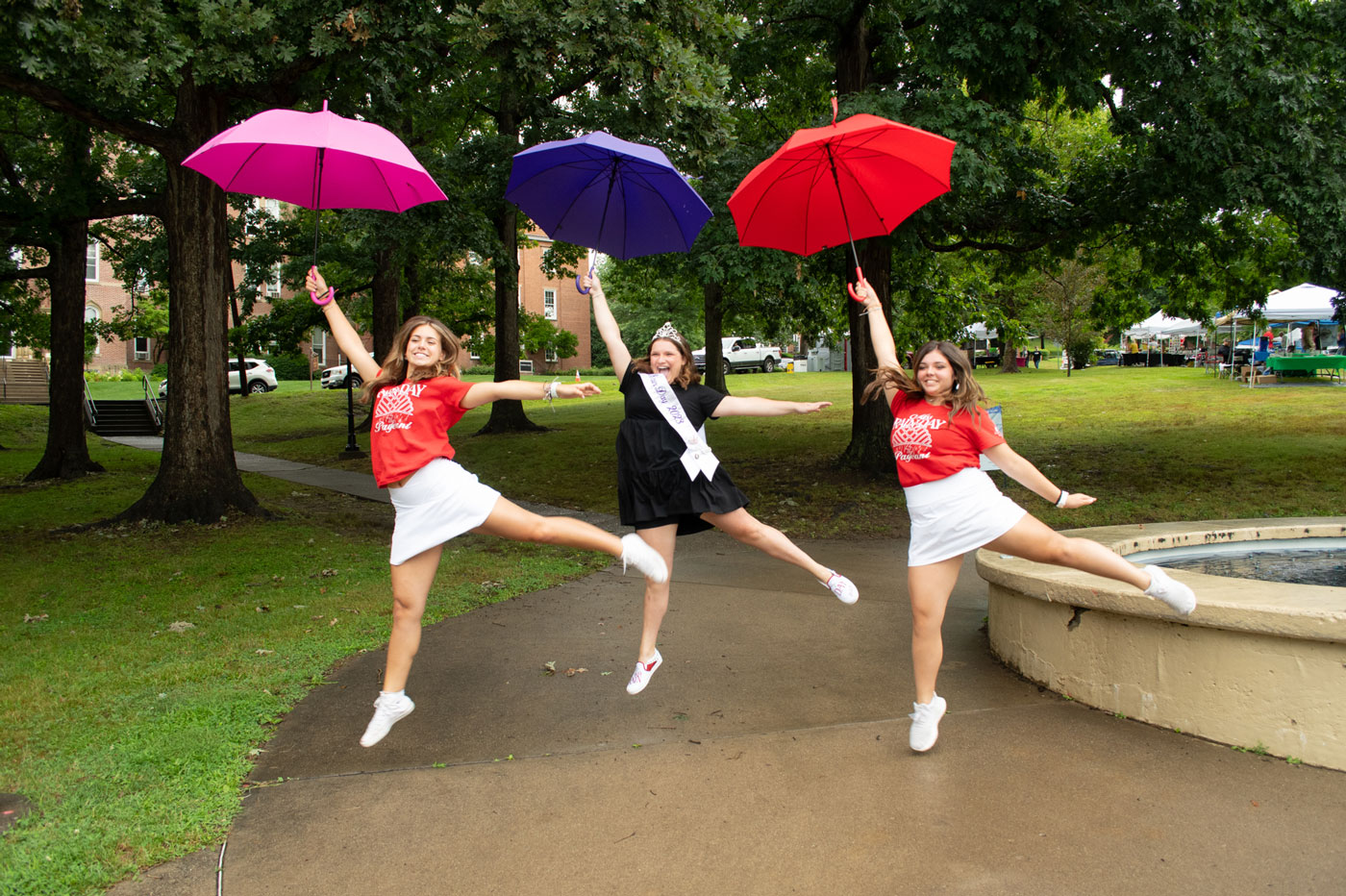 Three girls dancing with an umbrella