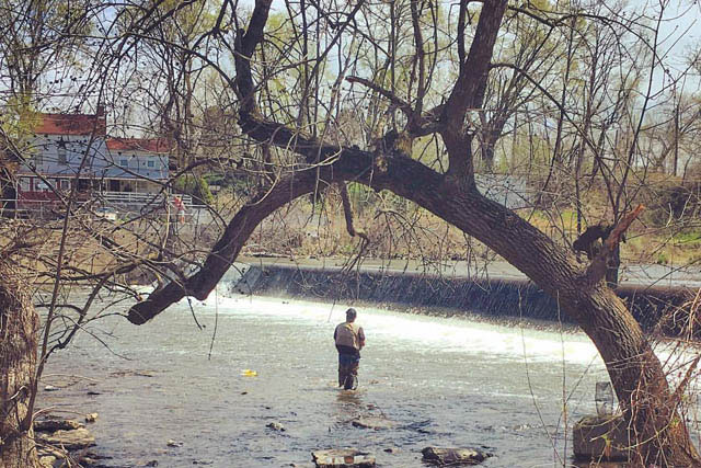 a person standing in the river run fishing